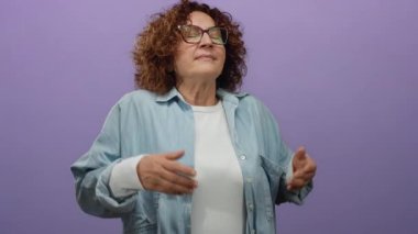 Pozitifliği kucaklayan, kolları açık, gözleri kapalı, canlı mor bir duvara karşı duran, neşe ve özgürlüğü ifade eden bir kadın..