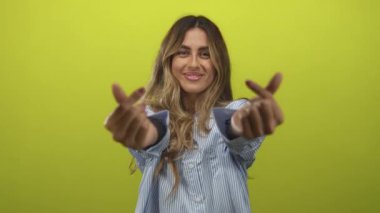 Sarışın genç kadın, sarı stüdyoda elleri ile kalp hareketi yapar. Aşk, aşk, aşk, aşk, aşk, aşk, aşk, mutluluk..