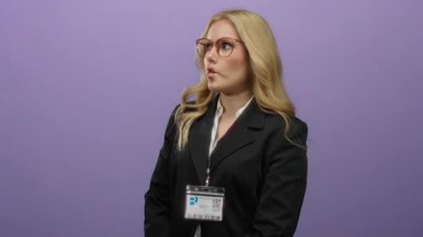 Mor bir arkaplanda komik balık suratları yapan, gözlük takan ve resmi bir ortamda neşeli duygular ifade eden bir kadın..