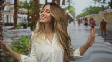 Kadın avuçlarını ileri doğru tutar, avuçlarında neşeli bir gülümseme, kendine güven dayanıklılığı..