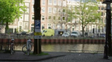 Amsterdam 'da bisikletler, ağaçlar, kanallar ve klasik mimariyle bulanık manzara, Hollanda' nın özünü ve kentsel manzarasını yumuşak bokeh ışığı altında yakalıyor..