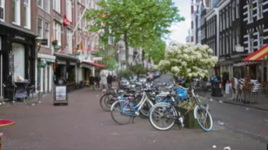 Amsterdam 'daki Bulanık Şehir Caddesi' nde bisiklet kuyrukları, hareketli binalar ve Hollanda 'nın şehir manzarasının özünü yansıtan bir bokeh etkisi..