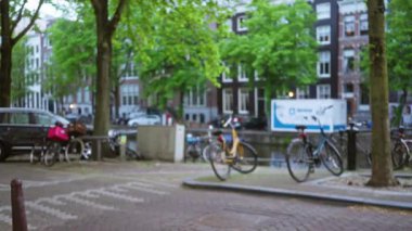 Bisikletler, Bokeh 'teki ağaçlar ve geleneksel binalarla dolu amber kanalı boyunca sıralanarak kentin ikonik bisiklet kültürü ve manzaralı caddelerini vurguluyor..