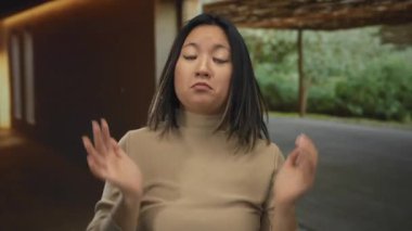 Rahat bir odada, doğal ışık ve nötr renklerle kayıtsızlığını ifade eden genç bir kadın, rahat ve düşünceli bir atmosferi aktarıyor..