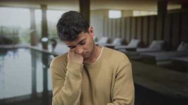 Adam spa salonunda esnerken elini dinlendiriyor. Yüzme havuzunda genç bir İspanyol erkek konuğun yanında kendini yorgun hissediyor..