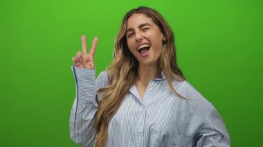 Yeşil ekran stüdyosunda kadın çıplak elle barış işareti gösteriyor; eğlence neşe gençlik.