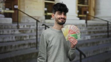 Elinde Norveç kronuyla gülümseyen bir adam şehir basamaklarında servetin ve maddi bolluğun olduğunu gösteren banknotlar tutuyor.