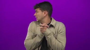 Erkek, arka plandaki Latin asıllı genç erkek, endişeli mor stüdyo sahnesine karşı el ele tutuşur..