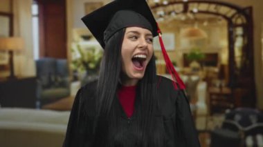 Mezuniyet elbisesi içindeki İspanyol kadın şık bir otel ortamında neşeyle kutlama yapıyor, gençlik başarısını ve gururunu yakalıyor..