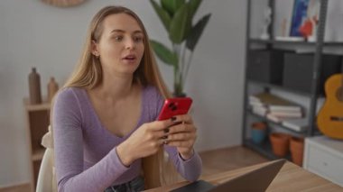 Modern oturma odasında akıllı telefon kullanan bir kadın, rahat ve rahat bir atmosfer sergiliyor, ev ortamlarında yaşam tarzı ve teknoloji teması için ideal..