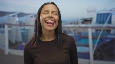 Deniz kıyısındaki bir teknede neşeli bir anın tadını çıkaran bir kadın neşeli bir ifadeyle dışarıda, rahatlatıcı bir tatilde genç bir İspanyol kadını vurguluyor..