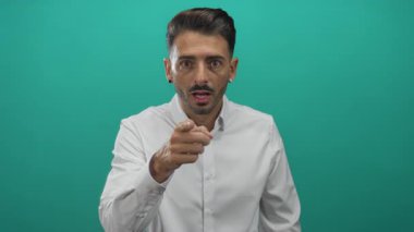 Beyaz tişörtlü genç İspanyol adam parmağıyla Tel Stüdyo 'yu işaret ediyor. Acil sürpriz tepki alarmı..