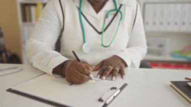 Klinikte bardakları çıkaran, steteskopla gözlerini ovuşturan, hastane odasındaki iş yerinde yorgunluk belirtileri gösteren, tıbbi uzmanların yorgunluğunu gösteren bir kadın..