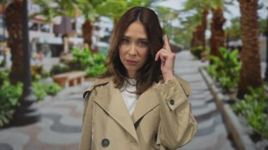 Etrafı gür ağaçlarla çevrili canlı bir park ortamını ve canlı bir açık hava atmosferini gösteren bir kadın..