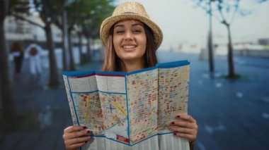 Şehir caddesinde elinde haritayla gülümseyen bir kadın, bir turistin açık hava alanlarını keşfettiğini söylüyor..