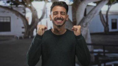 Sokakta göğsüne işaret eden yeşil kazaklı bir adam. Şaşırtıcı bir şekilde kafa karıştırıcı bir kimlik..