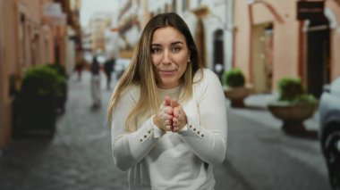 Şehirli geçmişi bulanık bir kadın, beyaz bir kazak giyiyor, görünür bir ürperti ile rahatsızlığını dile getiriyor, açık hava kış deneyimini yakalıyor..