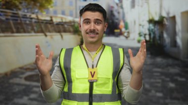 Şehir sokağında şaşırtıcı bir ifadeyle yansıtıcı yelek giyen İspanyol bir adam açık havada gönüllü iş yapıyor..