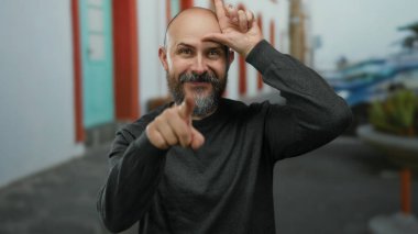 Sakallı adam, şehir sokaklarında alnında 