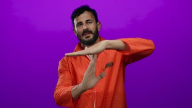 Hapishane tulumlu sakallı bir adam mor arkaplan araçlarına karşı mola veriyor hapisle ilgili bağlamda duraklıyor.