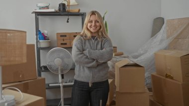 Yeni bir apartman dairesinde, içinde yelpaze ve raflar olan kutular düzenleyen bir kadın yakın zamanda taşınma deneyimini gösteriyor. Kapalı alandaki aktiviteler ve genç sarışınla taşınma sahneleri.