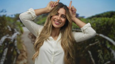 Kadınlar ormanda elleri ile boynuz hareketi yapar; oyun eğlence neşe enerjisi.