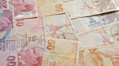 Türk banknotları dağılmış, farklı değerlerde lira, Türkiye 'deki mali işlemleri ve ekonomik kavramları sembolize ediyor.