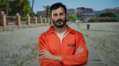 Sakallı, hapishane tulumu giyen İspanyol bir adam, sakin bir sahilde, arka planda deniz ve binalar bulunan, tefekkür ve özgürlüğün hikayesini anlatıyor..