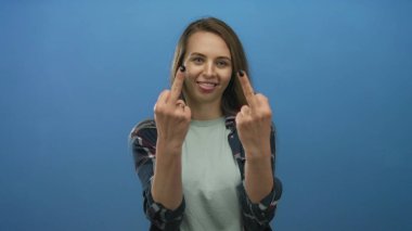 Kendine güvenen mavi ceketli, uzun düz saçlı, mavi arka planda neşeli yüz ifadeleri gösteren ve meydan okumayı sembolize eden bir kadın..