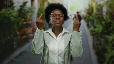 Şehir sokaklarında açık havada anlamlı jestler yapan bir kadın, duygularının ve yoğunluğunun arka planda bulanık olduğunu vurguluyor..