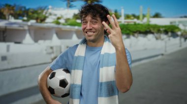 İspanyol adam gururla parmaklarıyla sayıyor, açık havada ayakta durup sporu ve enerjik enerjiyi coşkuyla kutluyor..