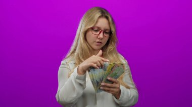 Gözlüklü genç kadın, Romanya lei banknotlarını parlak pembe bir geçmişe karşı sayıyor, finansal odak ve renkli bir ortamda bütçe gösteriyor.