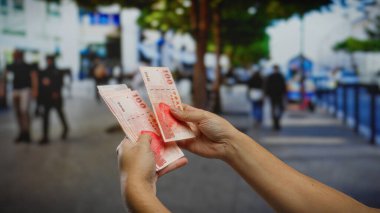 Meşgul bir şehir caddesinde Tayvan doları tutan eller, şehir hayatı arasında açık hava iş ve finansal işlemlerin özünü yakalıyor..