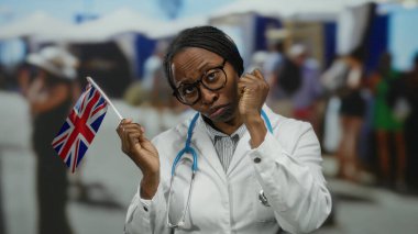 Sağlık ceketli bir kadın, İngiliz bayrağını açık hava pazarında tutuyor, ağlama hareketi yapıyor, kültürel ve profesyonel unsurları dinamik şehir ortamında harmanlıyor..