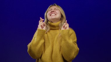 Umut dolu mavi bir arka planda, sarı bir kazakla umut ve iyimserliği ifade eden bir kadın..