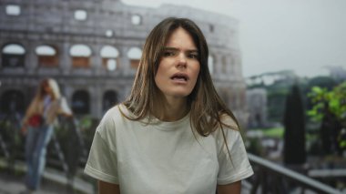 İkonik Roma Kolezyumu 'nun yanında duran İspanyol kadın, tarihi şehir manzarasının arka planına karşı ilginç bir ifade sunuyor, antik mimariyi modern moda ile harmanlıyor..