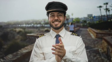 Kılavuz üniformalı, sakallı, güneşli bir sokakta gülümseyen, geçmişi bulanık, mutluluğu ve güveni somutlaştıran genç bir adam..