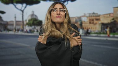 Siyah cüppeli hakim kadın Roma meydanında kollarını kavuşturuyor; yansıma dayanıklılığı yalnızlık gücü.