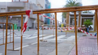 Güneşli bir kentsel alanda barikat ve uyarı bandıyla açık havada inşaat için kapalı bir bölüm gösteriliyor..