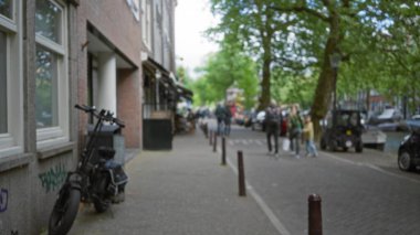 Bulanık sokak sahnesinde Avrupa şehir kaldırımlarında yürüyen insanlar, şehir yaşamını, bokeh etkisini ve görülebilir arka plan, ağaçlar ve bisikletleri gösteriyor..