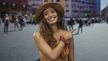 Turuncu bikinili genç İspanyol kadın gülümsüyor ve kalabalık caddede parmaklarını sağa sola gösteriyor; yaz eğlence mutluluğu heyecanı.