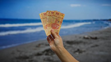 Şehirdeki deniz kenarındaki Meksika pesolarının el ele tutuşması para, yatırım ve açık hava ticareti temaları yaratıyor..