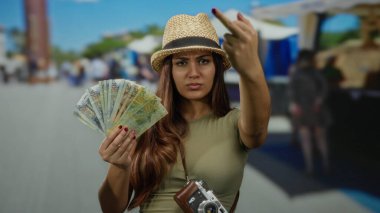 Peru tabanı tutan ve açık pazarda saldırgan hareketlerde bulunan kadın memnuniyetsizliğini dile getiriyor; kamera dinamik kentsel sahneleri gösteriyor.