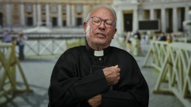 Aziz Peter Meydanı 'nda, Vatikan' da kıdemli rahip, geleneksel rahip kıyafeti giymiş, arka planda ikonik dini mimariyi düşünceli bir şekilde yansıtıyor..