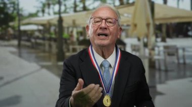 Takım elbiseli, terasta madalya takmış, sokak arkaplanında öpüşen, başarı ve sıcaklık saçan yaşlı bir adam..