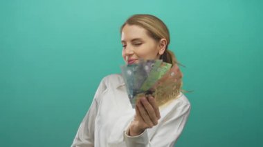 İzole edilmiş yeşil arka plan üzerinde Kanada doları tutan kadın finansal başarı ve para birimi temalarını sergiliyor.