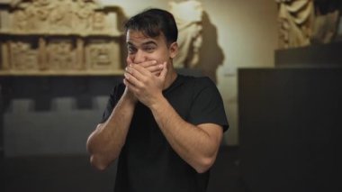 Müzedeki genç İspanyol adam, şaşkınlık içinde ağzı kapalı, antik sanatla çevrili, kapalı bir kültürel ortamda duygularını sergiliyor..