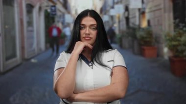 Uzun saçlı ve kilolu bir kadın hareketli bir şehir caddesinde kendine güvenerek duruyor zarafet ve özgüven saçıyor..