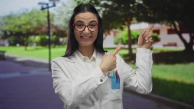 Üniformalı İspanyol kadın bilimadamı, güneşli bir park ortamında doğal bir ortamın altını çizen keşif ya da heyecanı dile getirirken şaşırdı ve yan yan gösterdi..