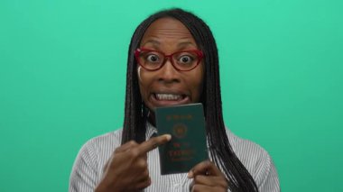 Tayvan pasaportlu bir kadın canlı yeşil arka plana gülümsüyor, seyahat ve kimlik belgelerine olan güvenini gösteriyor..